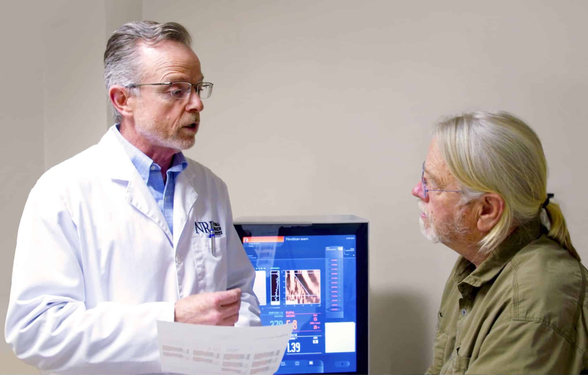 A physician holding test results and speaking to a patient