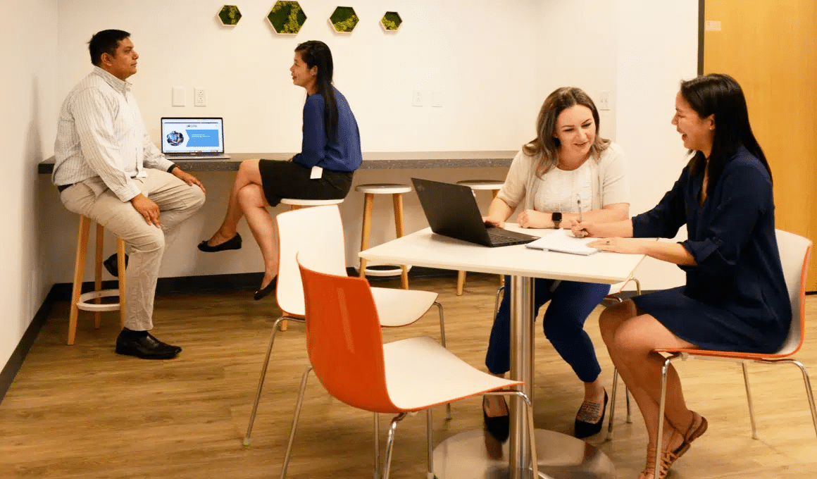 Two pairs of Akero employees collaborating in a communal workspace